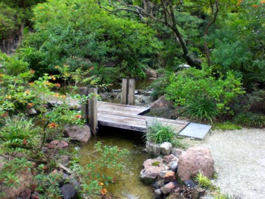 Petit pont japonais simple en bois sur cascade artificilelle